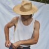 Man wearing the PIAVE II handmade straw fedora hat with a wide brim and natural woven texture.