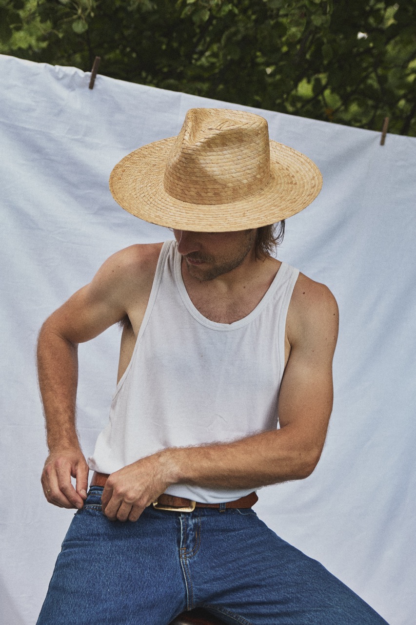 Man wearing the PIAVE II handmade straw fedora hat with a wide brim and natural woven texture.