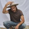 Man wearing the PIAVE handmade straw fedora hat with a wide brim and natural woven texture.