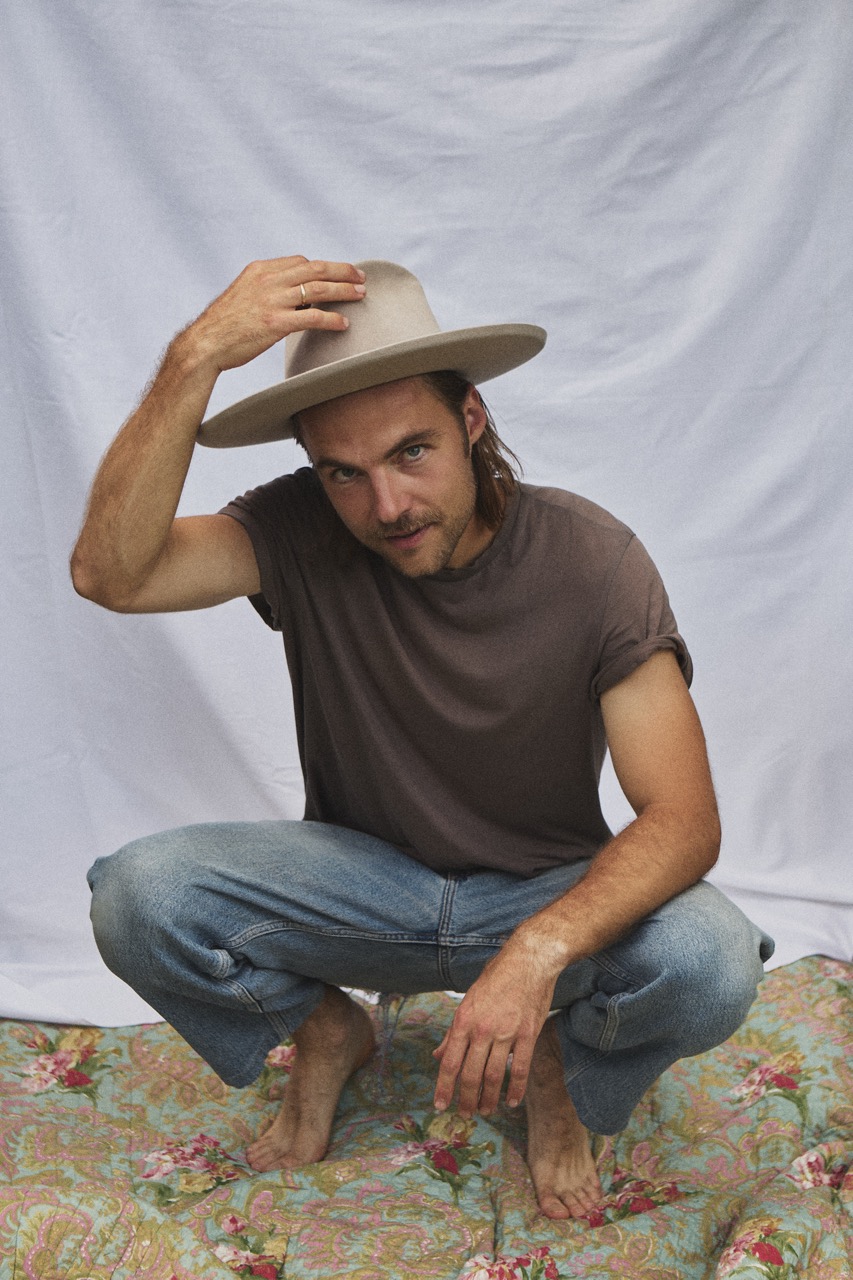 Man wearing the PIAVE handmade straw fedora hat with a wide brim and natural woven texture.