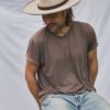 Man seated wearing the PIAVE handwoven straw fedora hat with a classic summer silhouette.