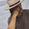 Close-up side portrait of a man wearing the PIAVE natural straw fedora hat outdoors.