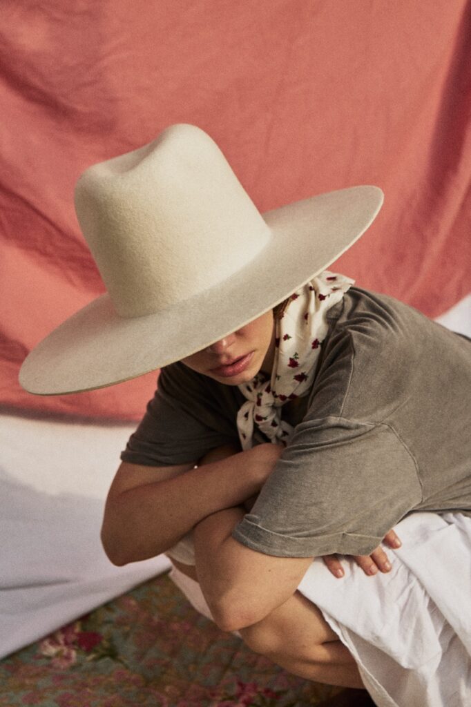 Model wearing a large white handcrafted fur felt hat by BArtekProjekt.